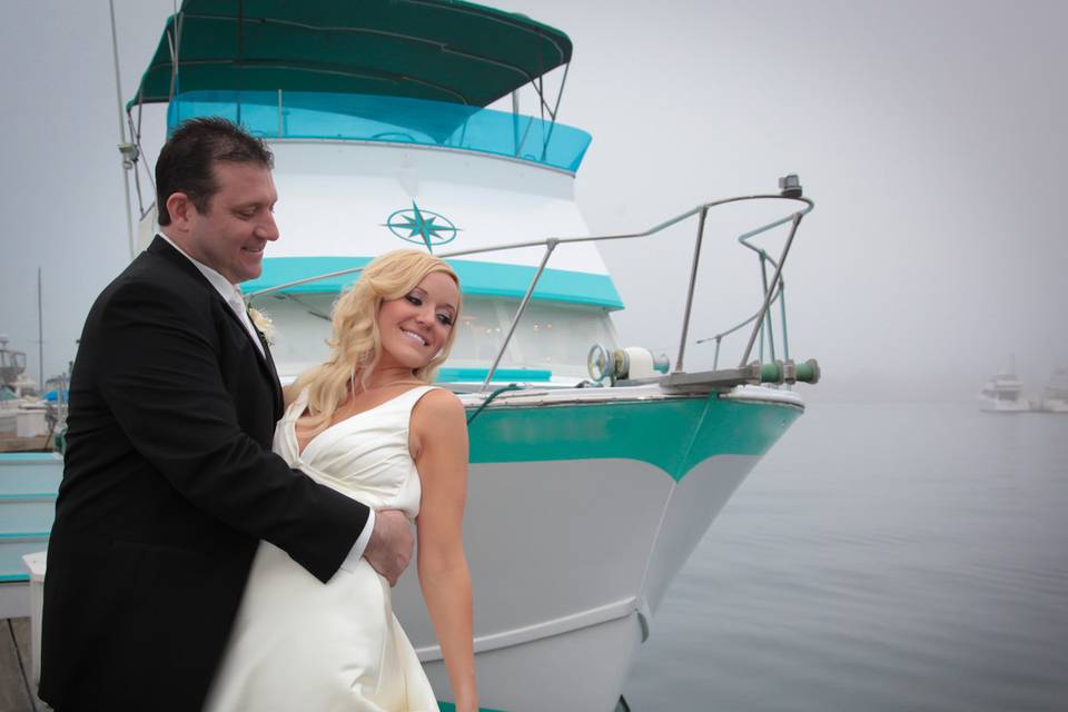 Couple in front of boat on misty water