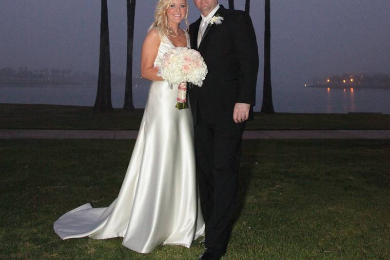 Couple in front of tall palms with misty bay behind them