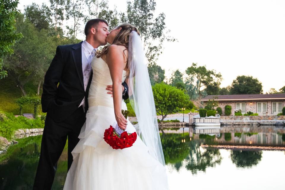 Couple kissing on ledge over reflecting pool