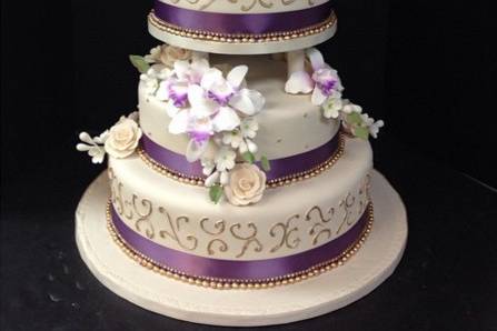 White wedding cake with purple ribbon