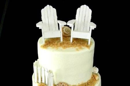 White chocolate cake with white chocolate buttercream. fondant accents and decorative shells