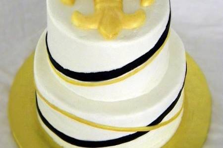 White cake with praline filling, butter cream icing and fondant accents. Bride and Groom are Saints fans