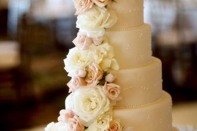 Cascading, full-petaled flowers by Yvonne Design add romance to this towering five-tiered cake.  Photo by Frank Amodo.