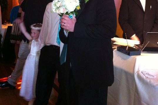 Groom holding her brides bouquet