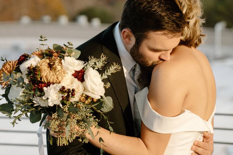 Groom kissing bride's shoulder