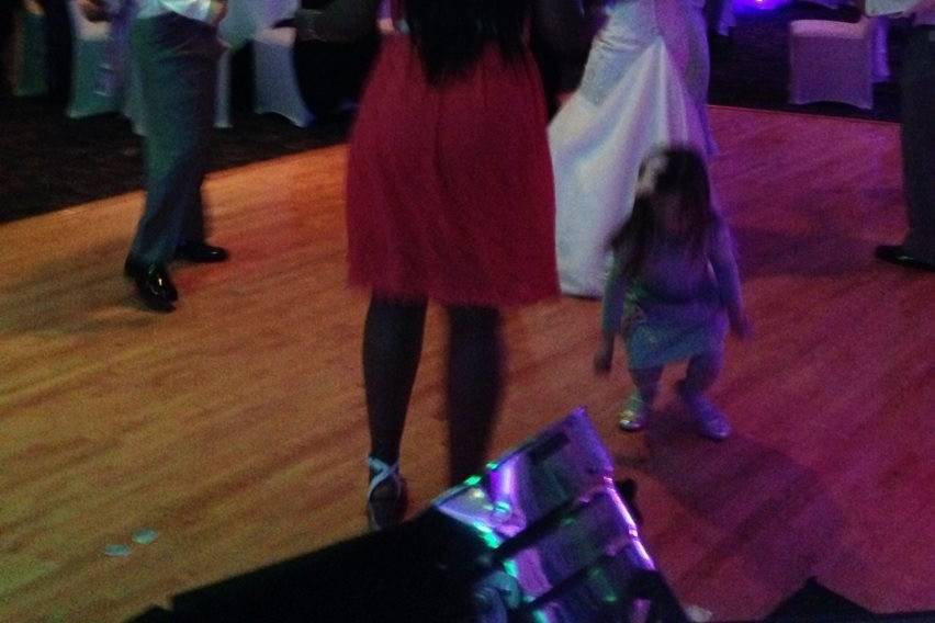 Guests dancing at a wedding reception at 5Eleven Palafox in Pensacola. You can see  the custom monogram, uplighting, and our 