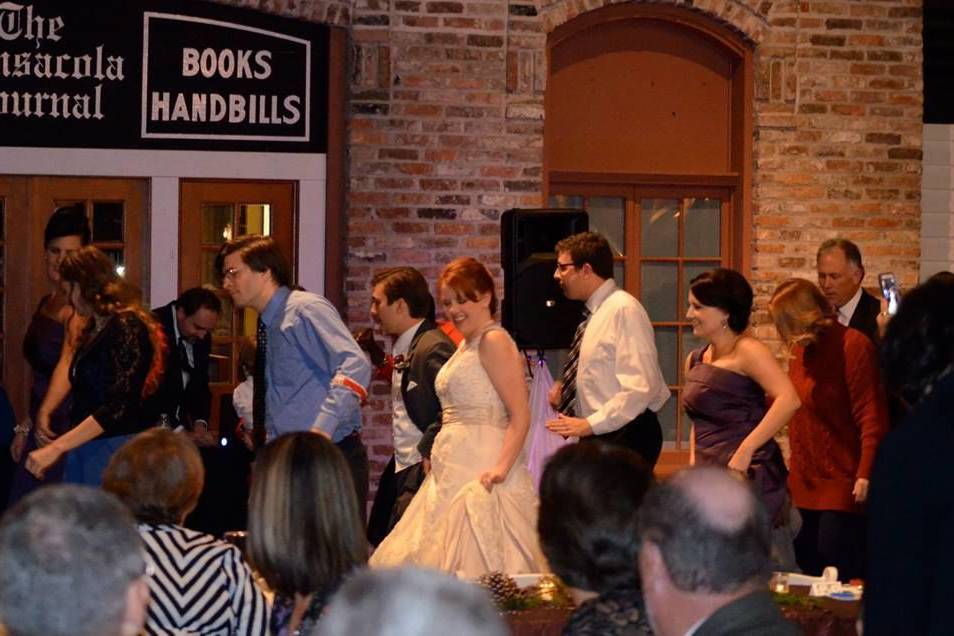 Bride, Groom, and everyone having fun at a wedding reception at the Museum of Commerce in downtown Pensacola.