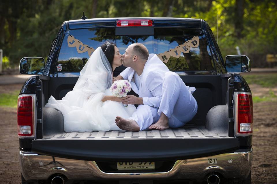 Hawaii country style wedding married on the east shore of Oahu. A little romance in the back of the pickup truck for this newly married couple.