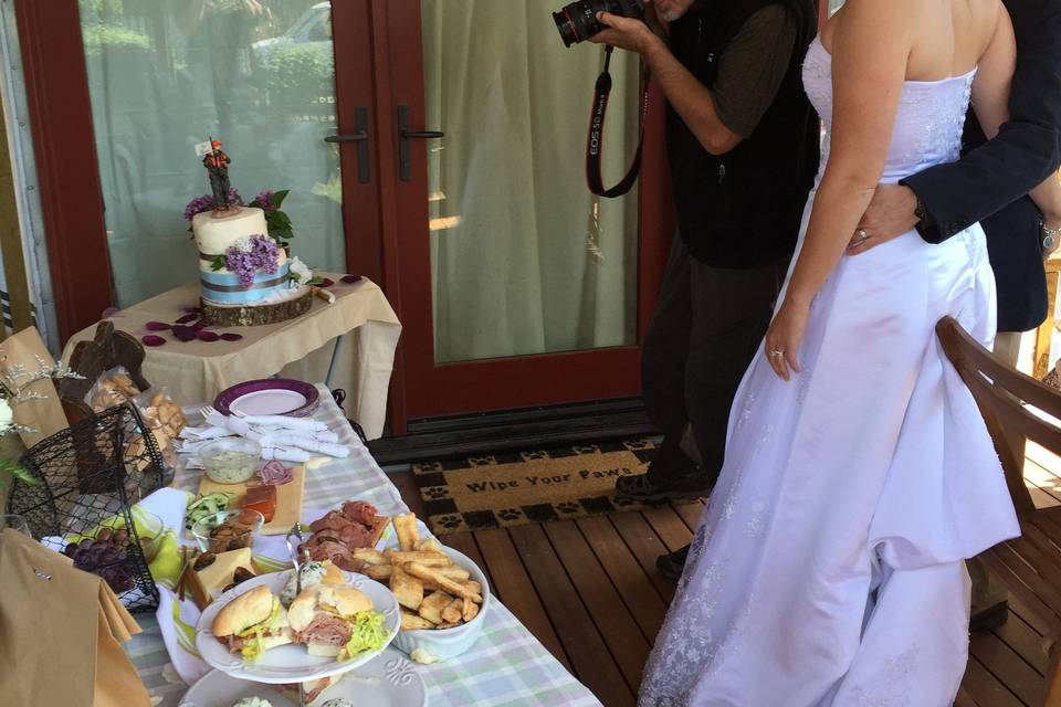 Paul Murray takes photos of the cake while Mike and Meredith look on.Photo by Becky McGill Mull of Azure Alaska Weddings.