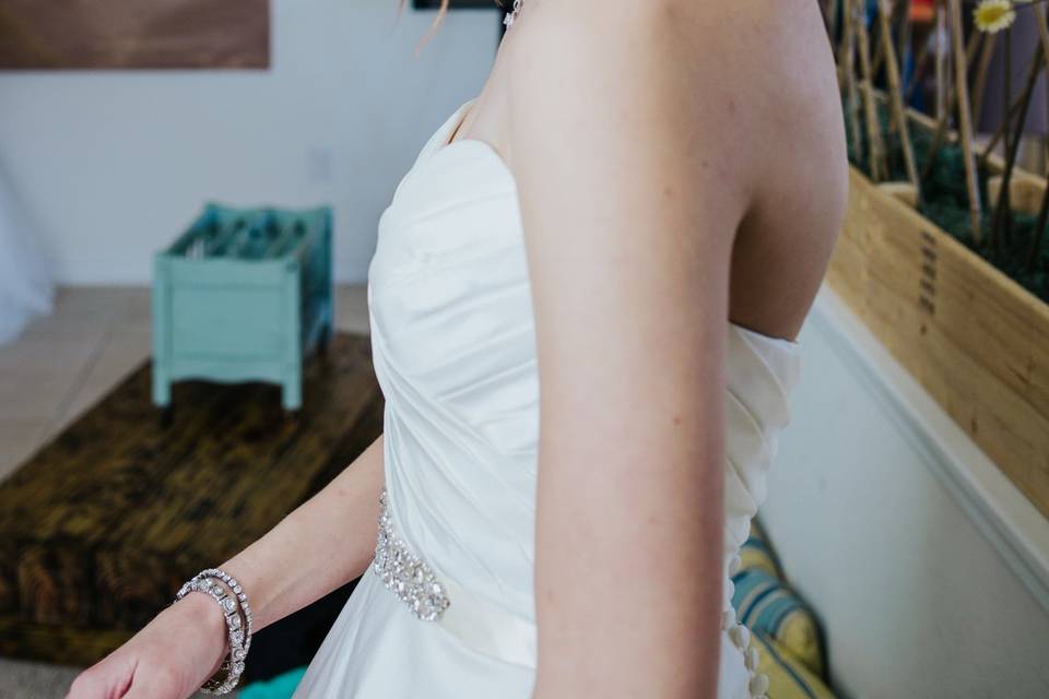 Bride putting on dress