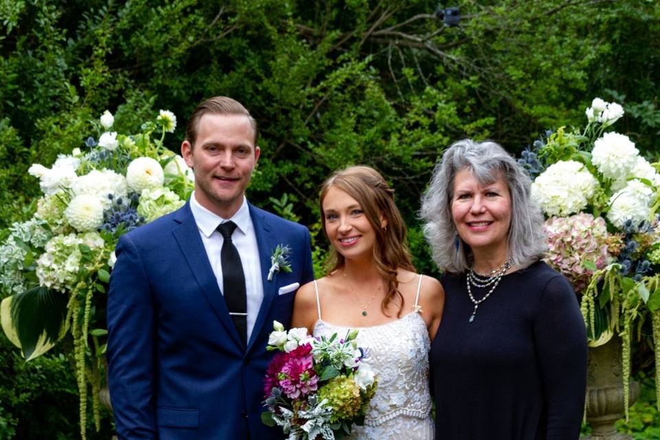 Newlywed couple with the officiant