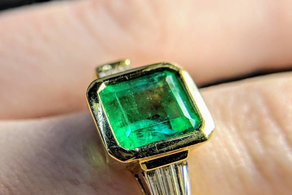 bezel set emerald and diamond engagement ring in 18k yellow gold Secrète Fine Jewelry in Bethesda, MD and Washington, DC