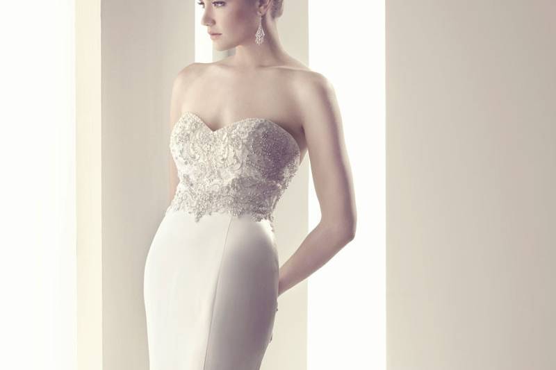 B086A stunning Italian Duchess Silk fit and flare silhouette gown. The strapless sweetheart front and back necklines are embellished with detailed embroidery, Swarovski Crystals, pearls, rhinestones, and silver backed crystal sequins. Matching Italian Duchess Silk buttons complete the train.
