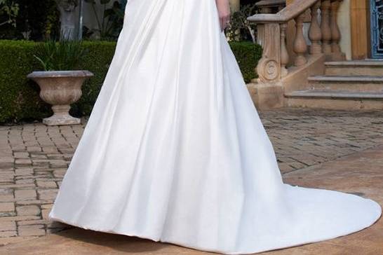 Style B014This breathtaking Silk Charmeuse gown has a sweetheart neckline and is sure to bring out the inner goddess in all brides. The spaghetti straps criss-cross in the back and with a sash that flows with elegance. This gown is perfect for destination weddings.