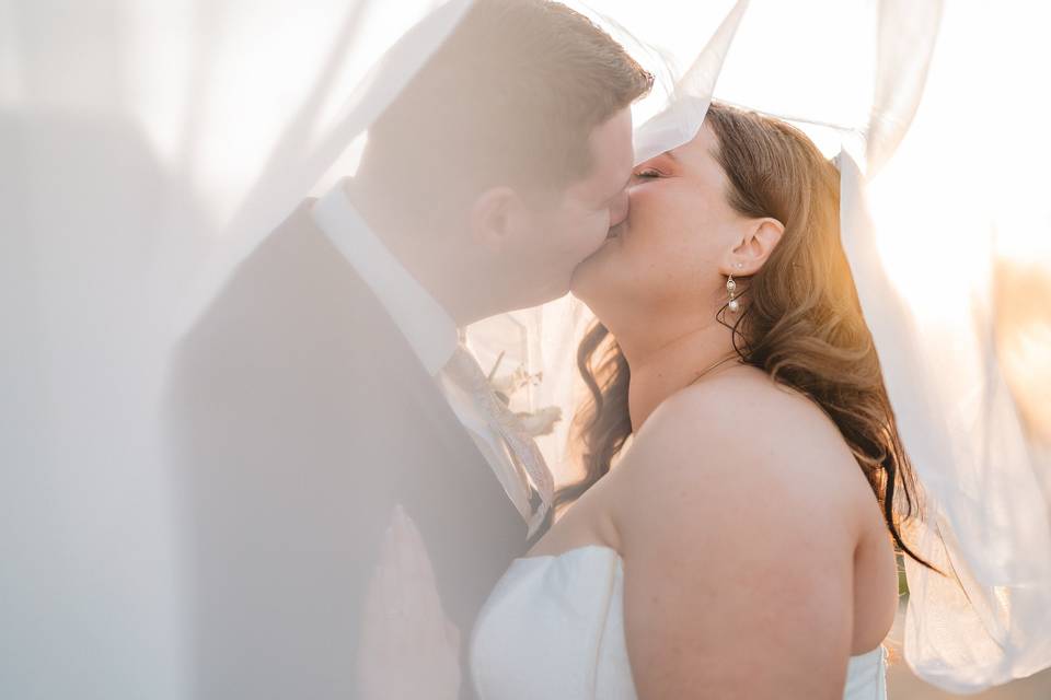 Bride and groom under veil