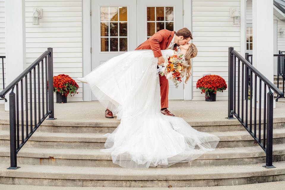 Groom dipping bride on steps