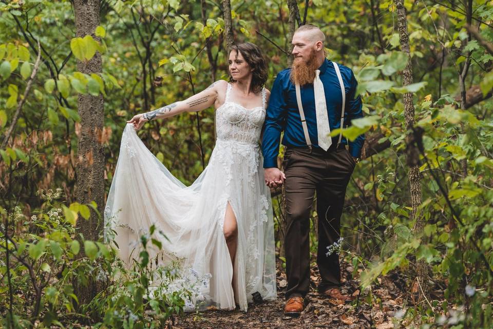 Bride raising dress in woods