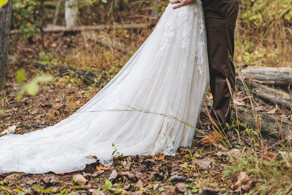 Bride and groom in forest kiss