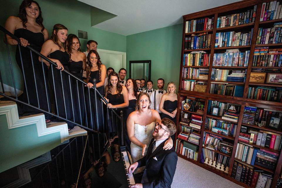 Couple at piano with wedding party