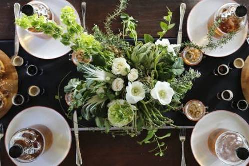 Earthy textures pair with distinctive florals for this lush centerpiece. Herbs and vegetables (artichokes, asparagus, and more) bring visual interest. Perfect for a rustic garden wedding, such as at Farm At South Mountain, where this was first seen.