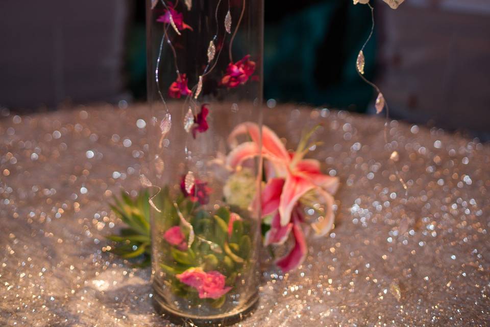 Drama, elegance, stunning design. If these are your goals, and you enjoy the confluence of wood, glass and florals, this is the perfect centerpiece. Can be created tall enough that guests can still see across the table. Colors, flowers and style of wood can be customized to fit your event.