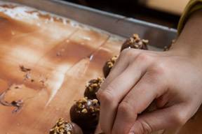 Dipping Hazelnut truffles in tempered chocolate.