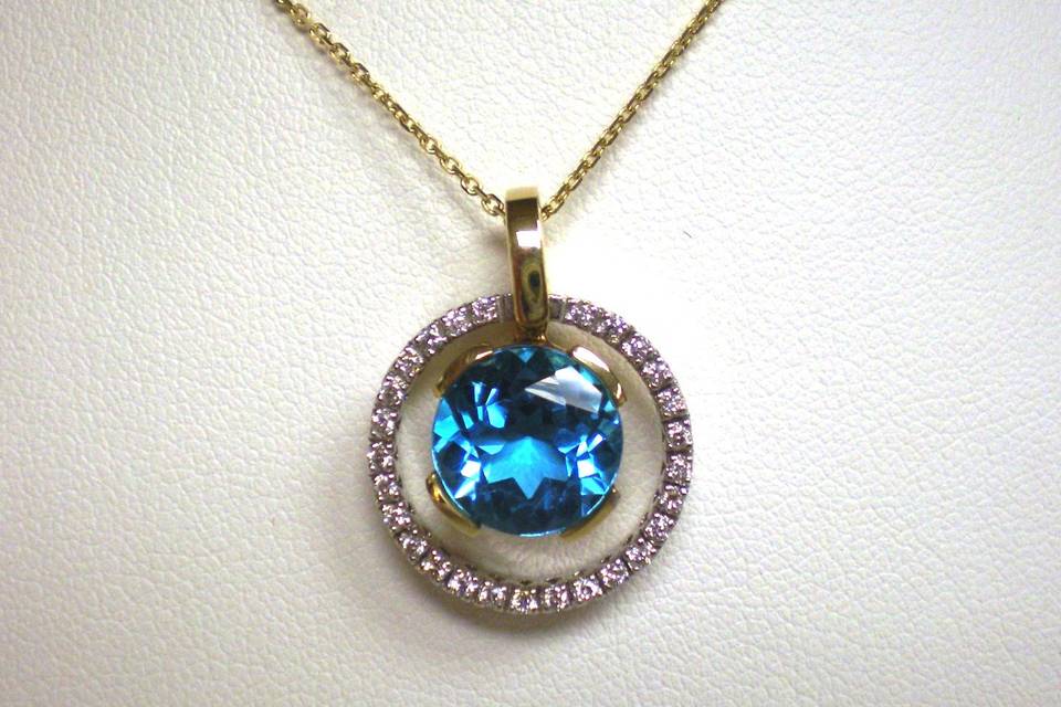 With Dual Tone being popular, a Blue Topaz and Diamond pendant is a great way to show off both 14K Yellow Gold and 14K White Gold. The Blue Topaz is on an oscillating bale so it moves with your every motion.