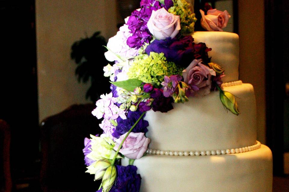 Floral wedding cake with bottom tier sculpted to look like a knobby tire, complete with edible spokes!