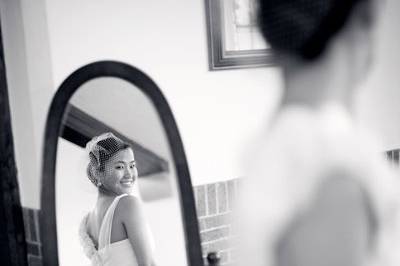 A happy bride admires her gown while waiting for the ceremony.