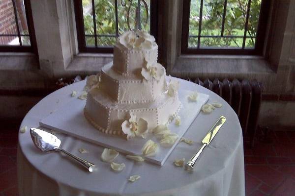 Three tier white buttercream wedding cake with white orchids