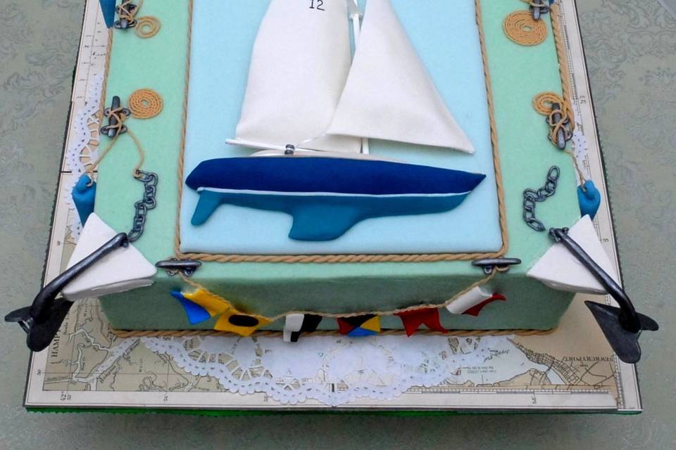 Twelfth Anniversary Cake for a sailing couple.  Toasted Hazelnut Cake with Bittersweet Chocolate filling covered in White Chocolate Ganache.