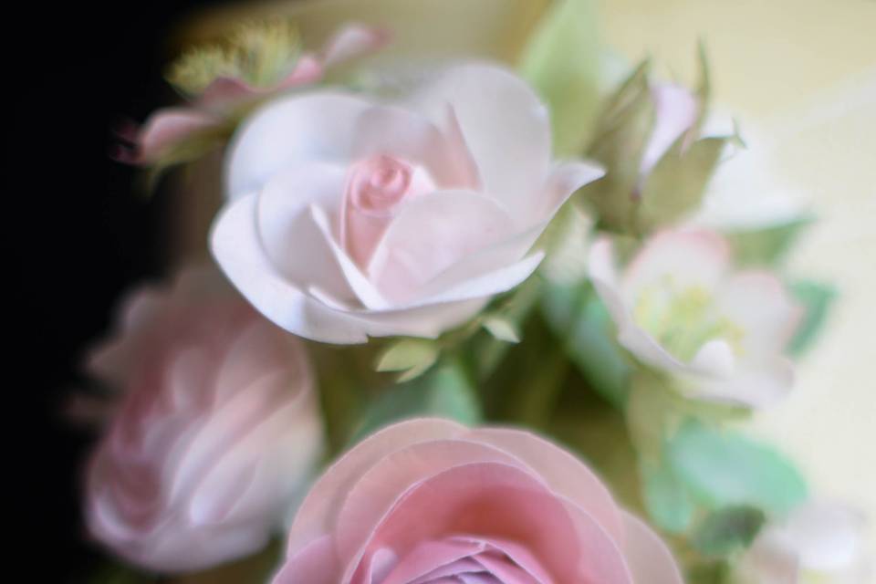 Handcrafted roses and ranunculus are made from edible wafer paper.