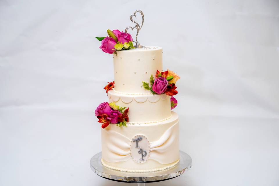Three tier wedding cake with hearts on top