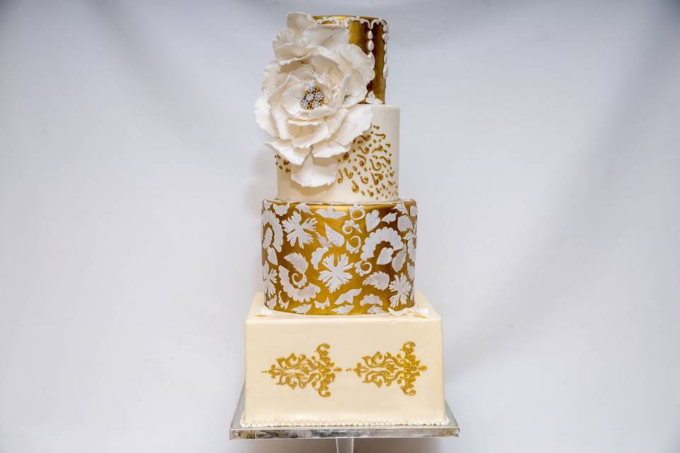 Four tier white and gold cake