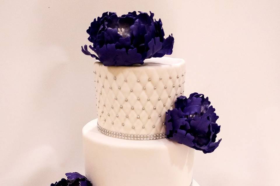 Three tier cake with large purple flowers