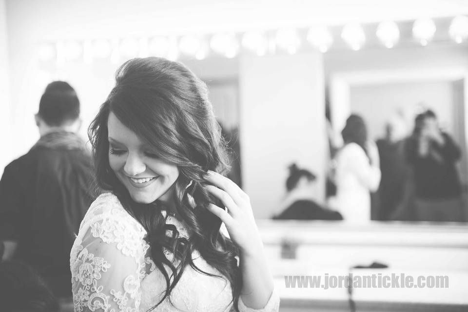 Bride admiring her dress. Bridal prep. Black and white candid shot.