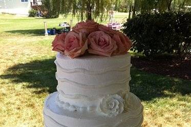 Three tier wedding cake with flower on top