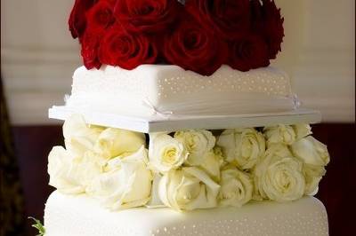Plainly decorated cake enhanced with roses.