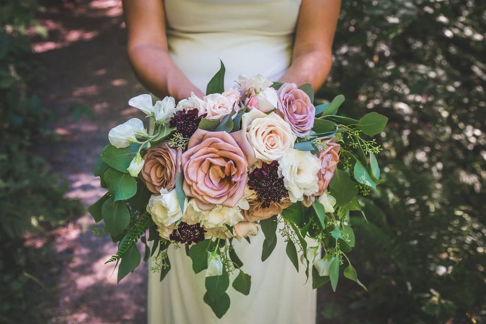 Romantic open mauve and cream roses, scabiosa and sweet peas are gorgeous against the mixed eucalyptus greenery for this Hoyt Arboretum Redwood Deck wedding. Photo courtesy of Jamie Wegner Photography