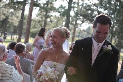 Bride and groom kiss among the fallen flower petals at Sundance Mountain Lodge in Monument, Colorado