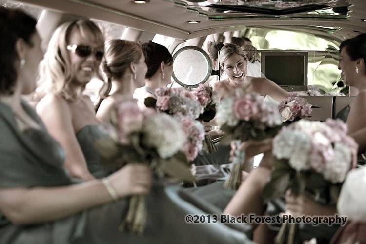 Bride and her bridesmaids during the limo ride to the church. Candid photography
