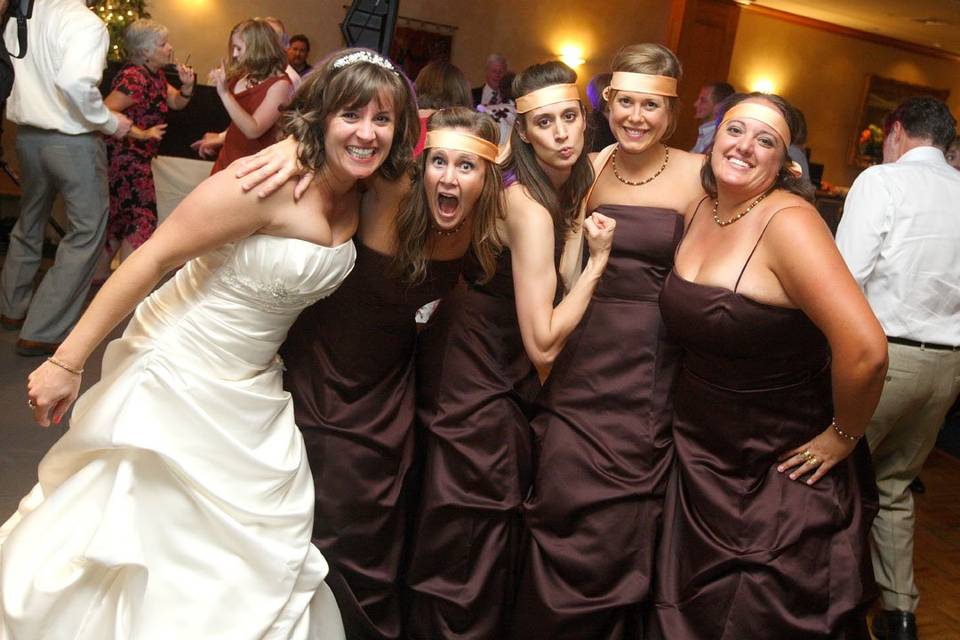Fun photo of the bride and her bridesmaids on the dancefloor at the reception