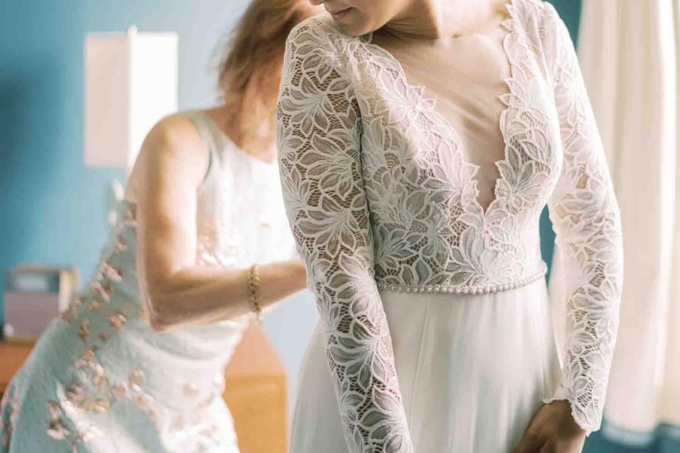 Mom buttoning bride's dress