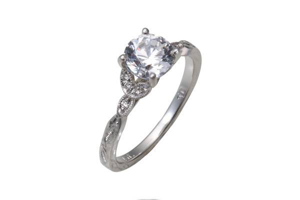 A classic engagement ring with a round sapphire center stone. Around the sapphire there are both round and straight baguette diamond accents.