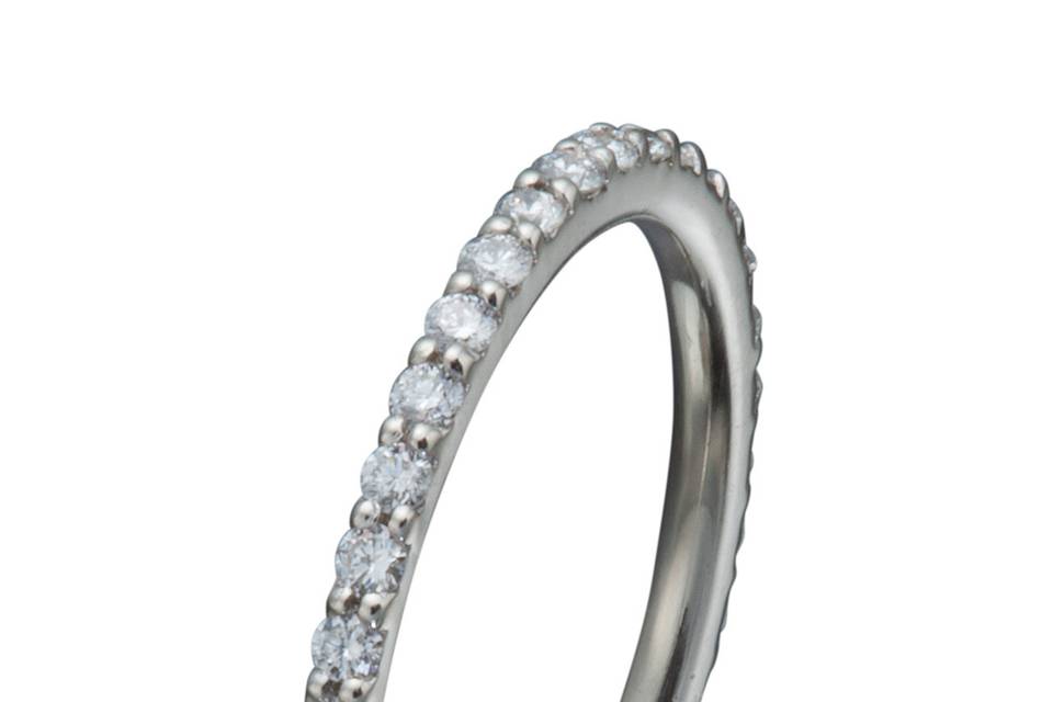 A platinum and diamond eternity band with hand engraving and milgrained edges.