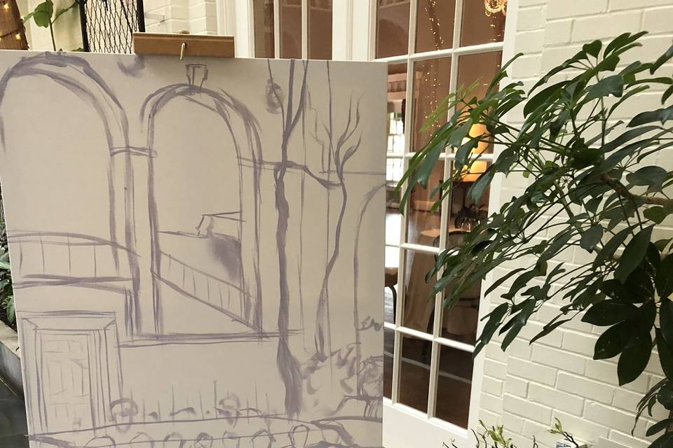 The artist starts by sketching the scene with a thin coat of paint before guests arrive.