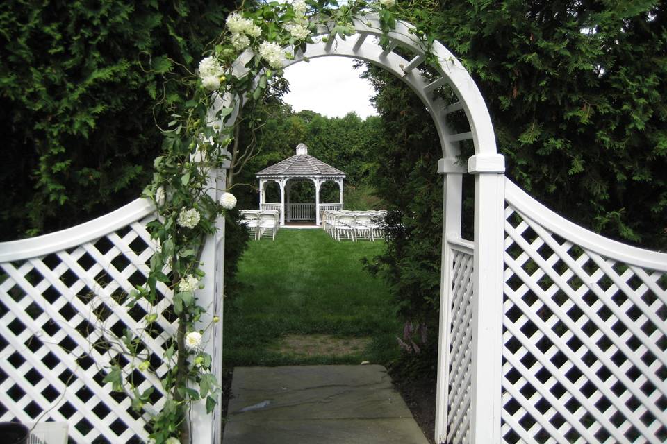 White arbor decorated in shades of pink.