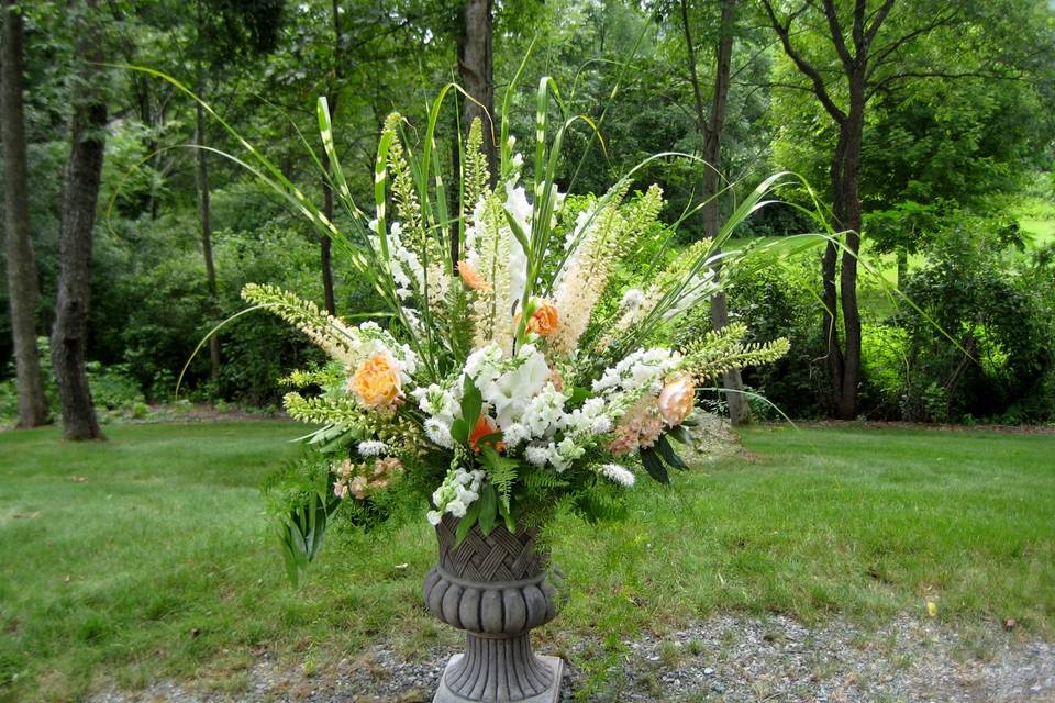 Matched floral displays on pedestals frame the landscape background.