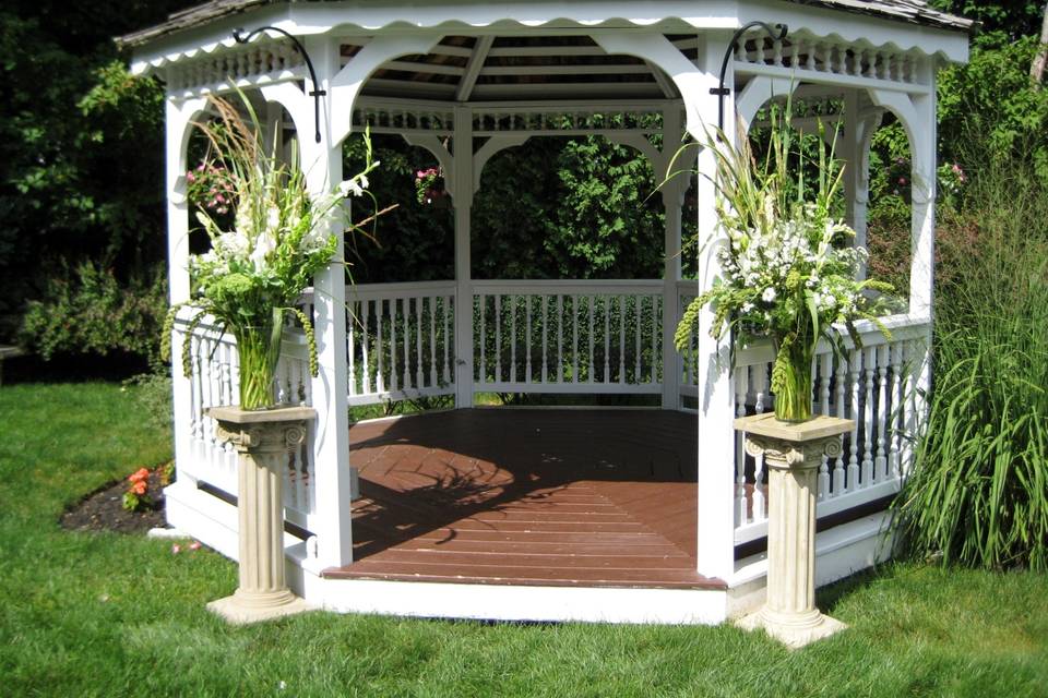 White arbor decorated in shades of pink.