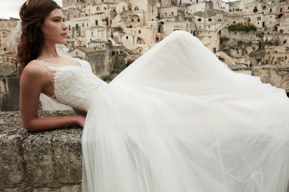 BHLDN Cassia Gown	<br>	Trimmed in sparkle, this effortless v-neck gown exudes romance. Intricate illusion lace, replete with glistening beads, ascends from the bodice and a frothy tulle skirt finishes the look. A bonus: pearl buttons down the back!